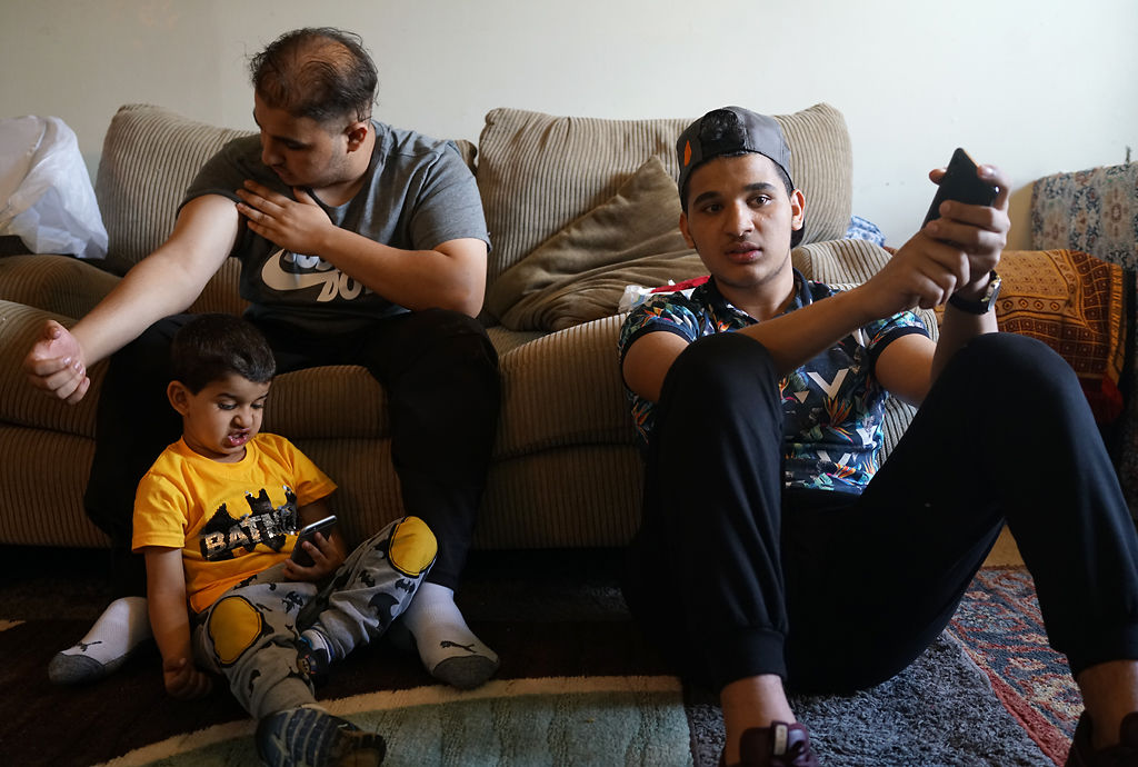 Brothers Abbas, Mohamed Baqer, and Hussein Al Hraishawi sit in their home